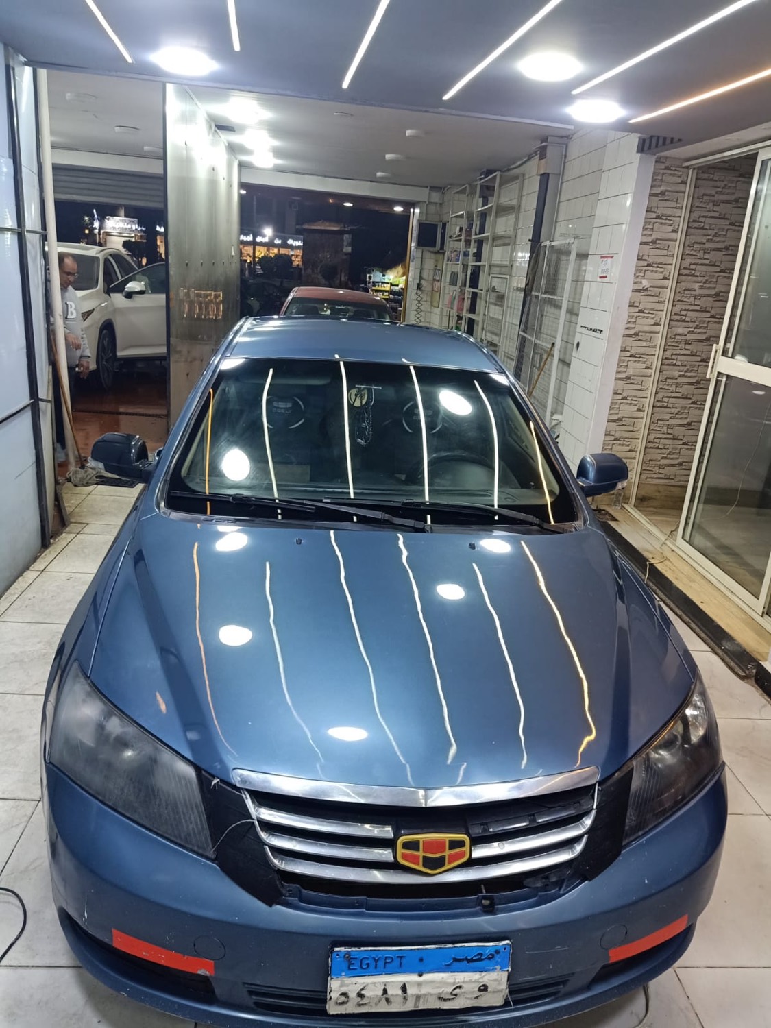 سيارة زرقاء لامعة داخل المركز بعد الغسيل